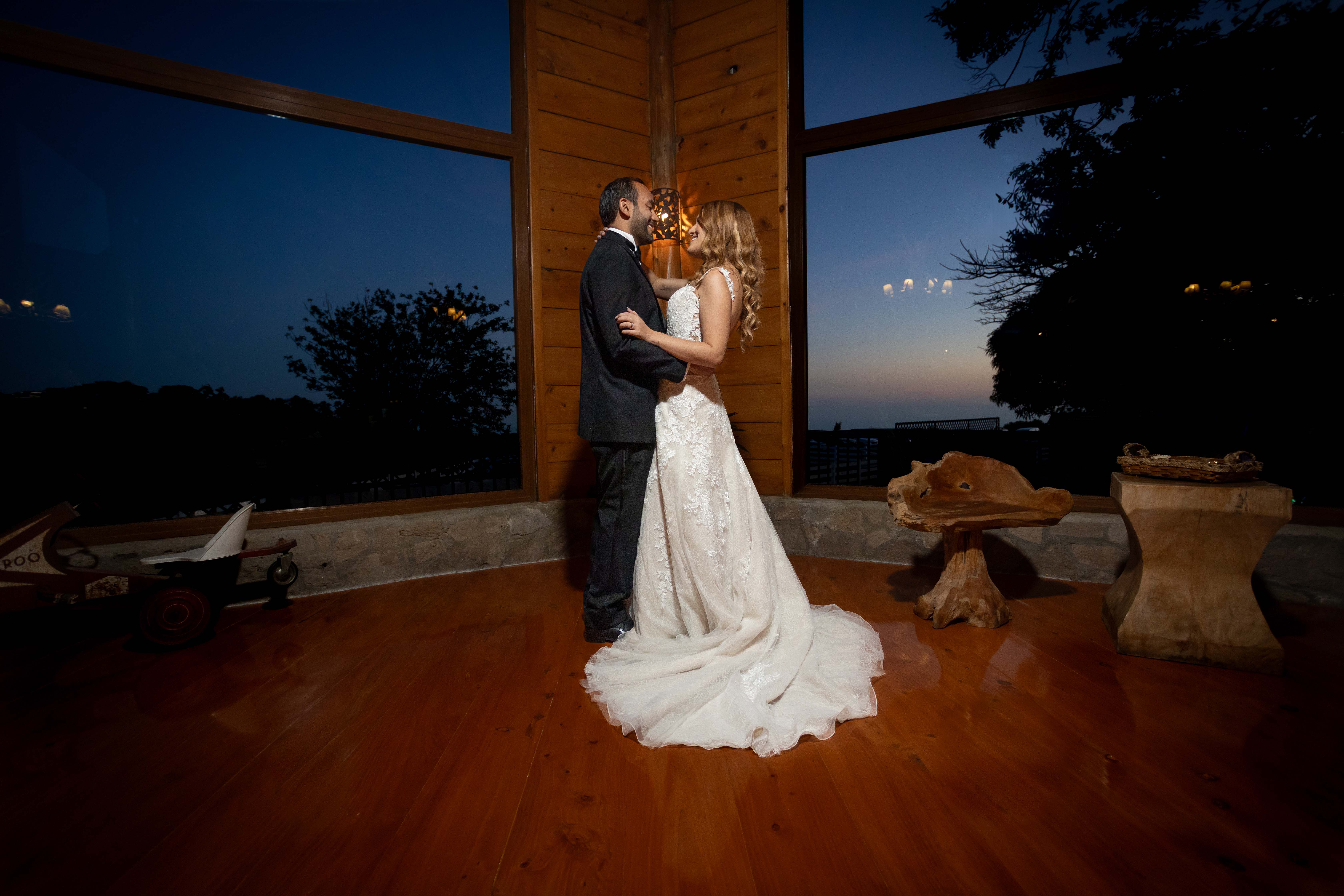 Retrato nocturno dramático y elegante de novios compartiendo un momento íntimo