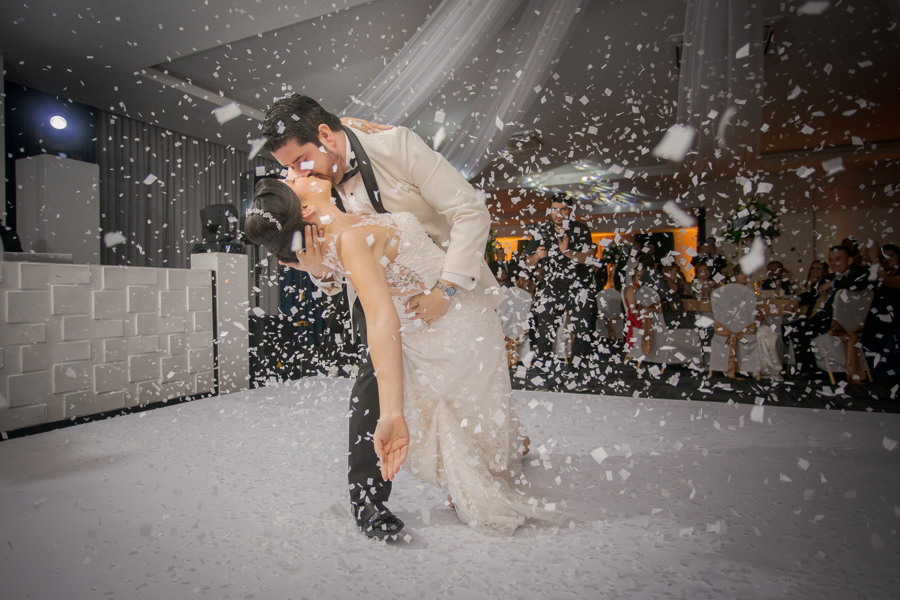 Novios bailando y sonriendo en su primer baile de esposos en la recepción