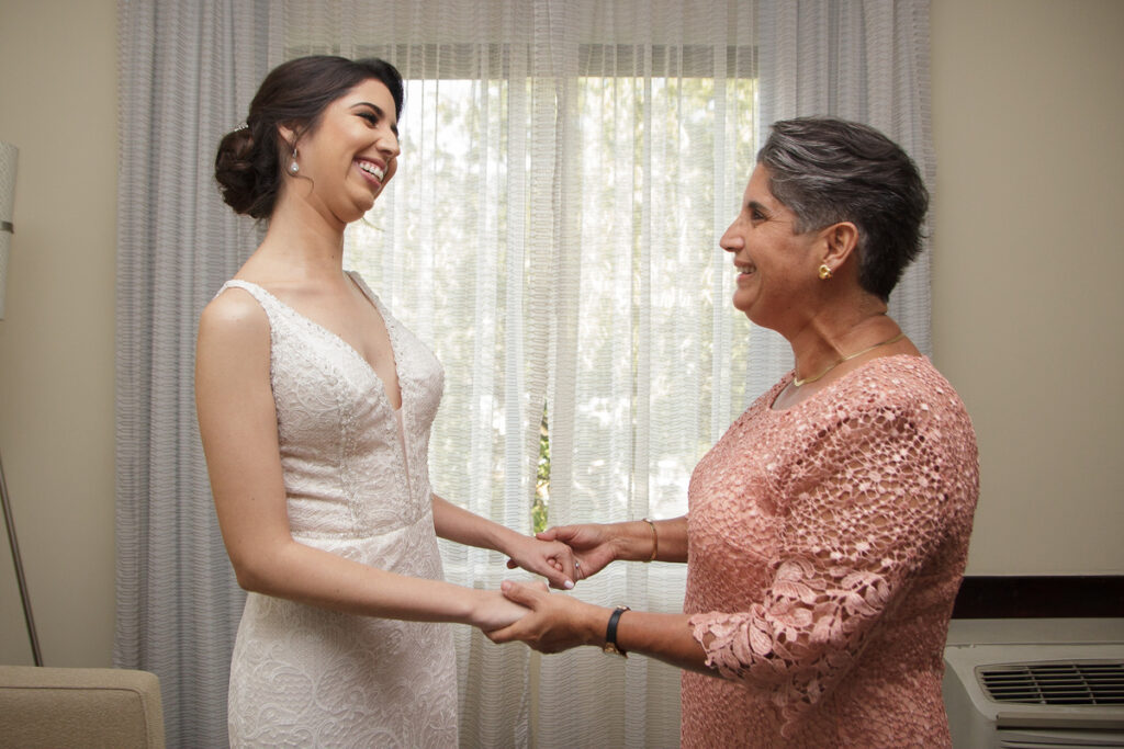Novia riendo espontáneamente junto a invitada en la pista de baile